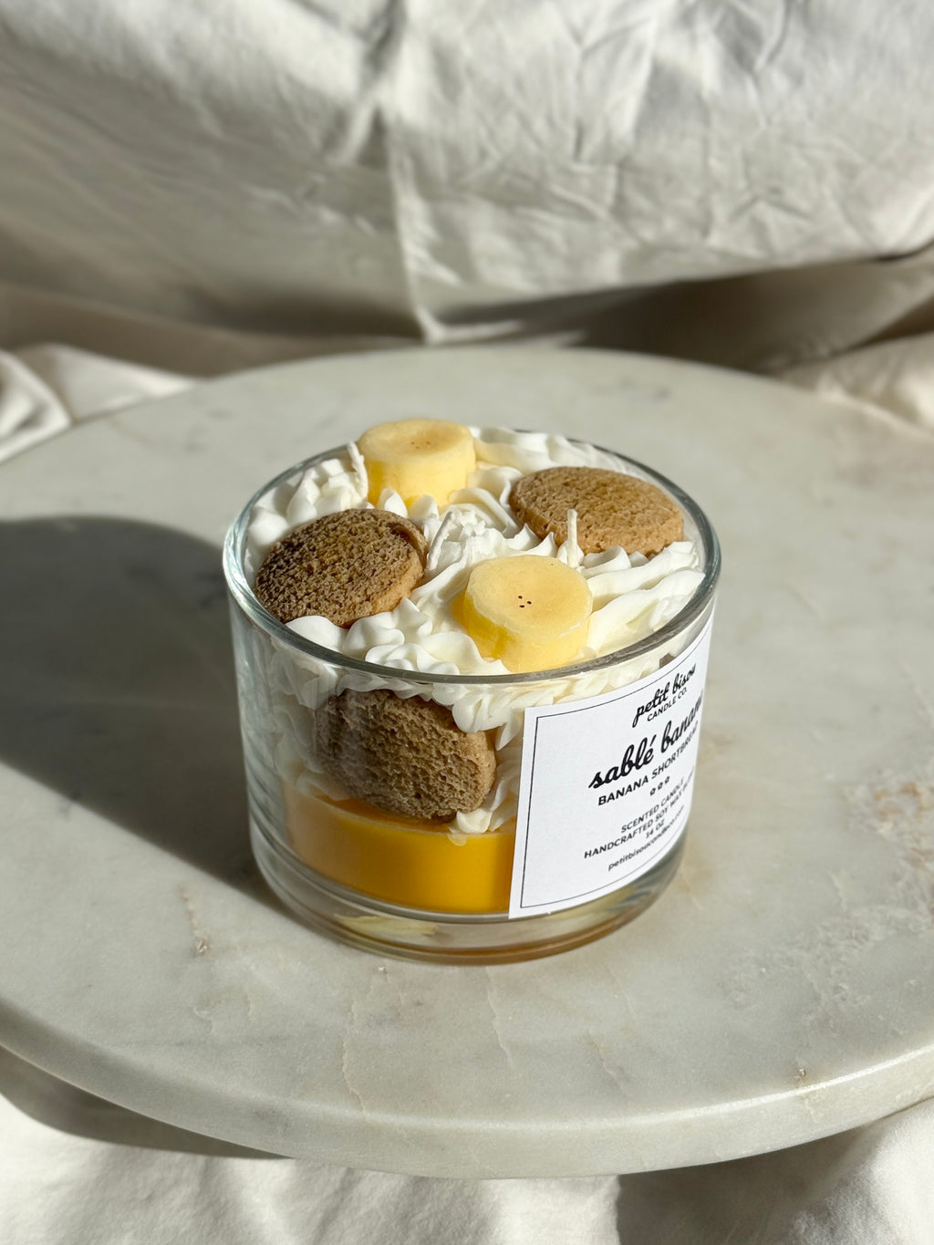 Side view of hand-poured Banana Shortbread scented candle by Petit Bisou, dessert-inspired and handmade in New York