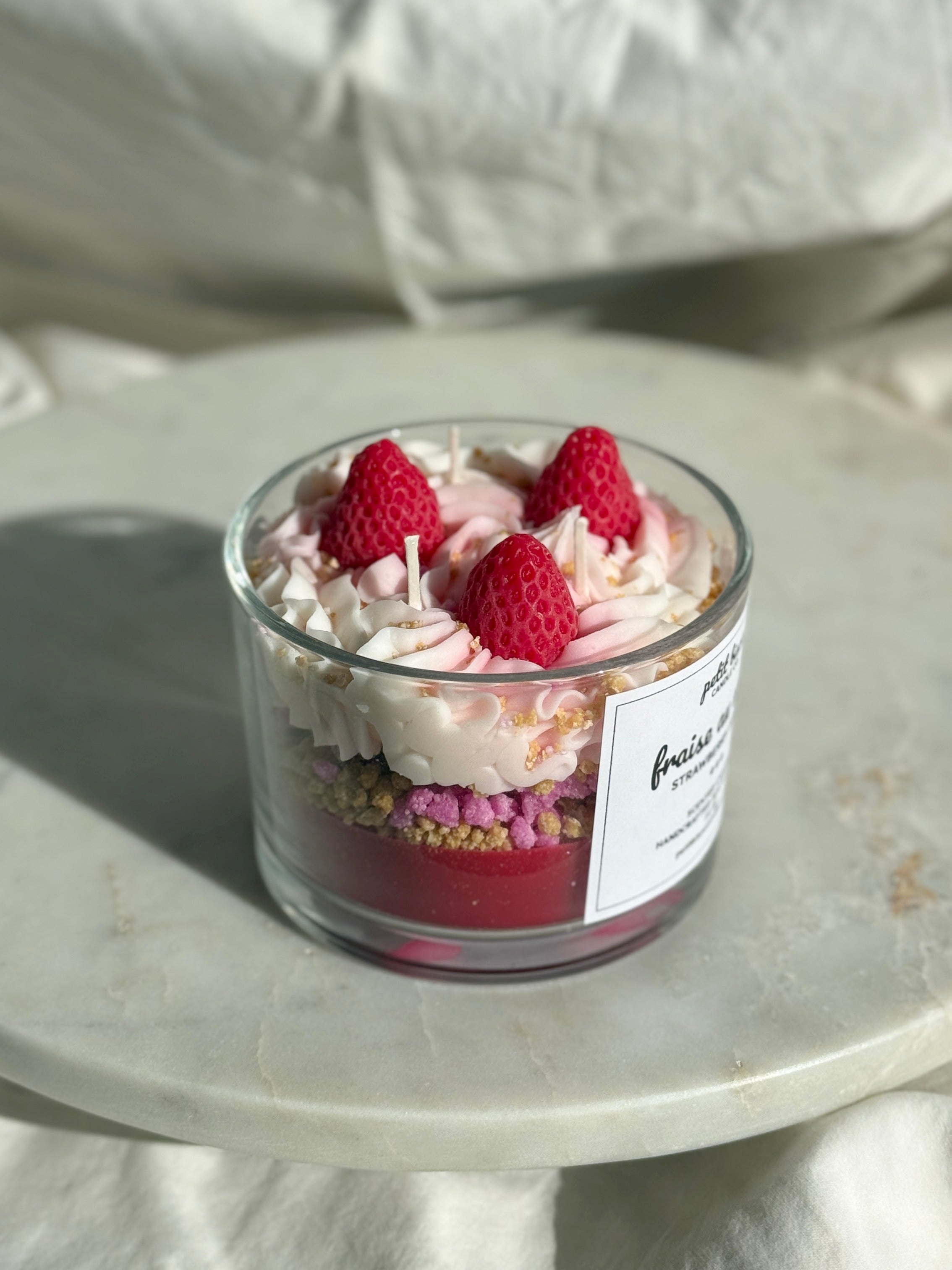 Side view of hand-poured Strawberry shortcake scented candle by Petit Bisou, dessert-inspired and handmade in New York